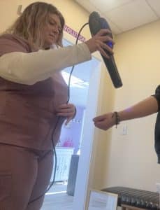 Sonic Serenity's Shelbee McCann assisting an AO Scan client with an AO Infinity Terahertz Wand session.
